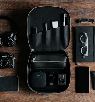 black headphones beside camera on top of wood