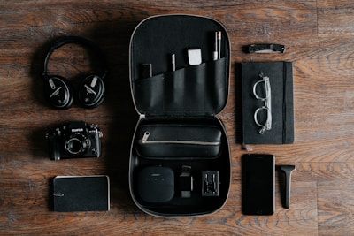 black headphones beside camera on top of wood