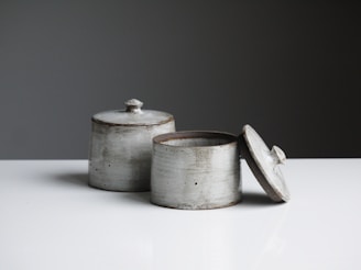 two grey containers on wooden table