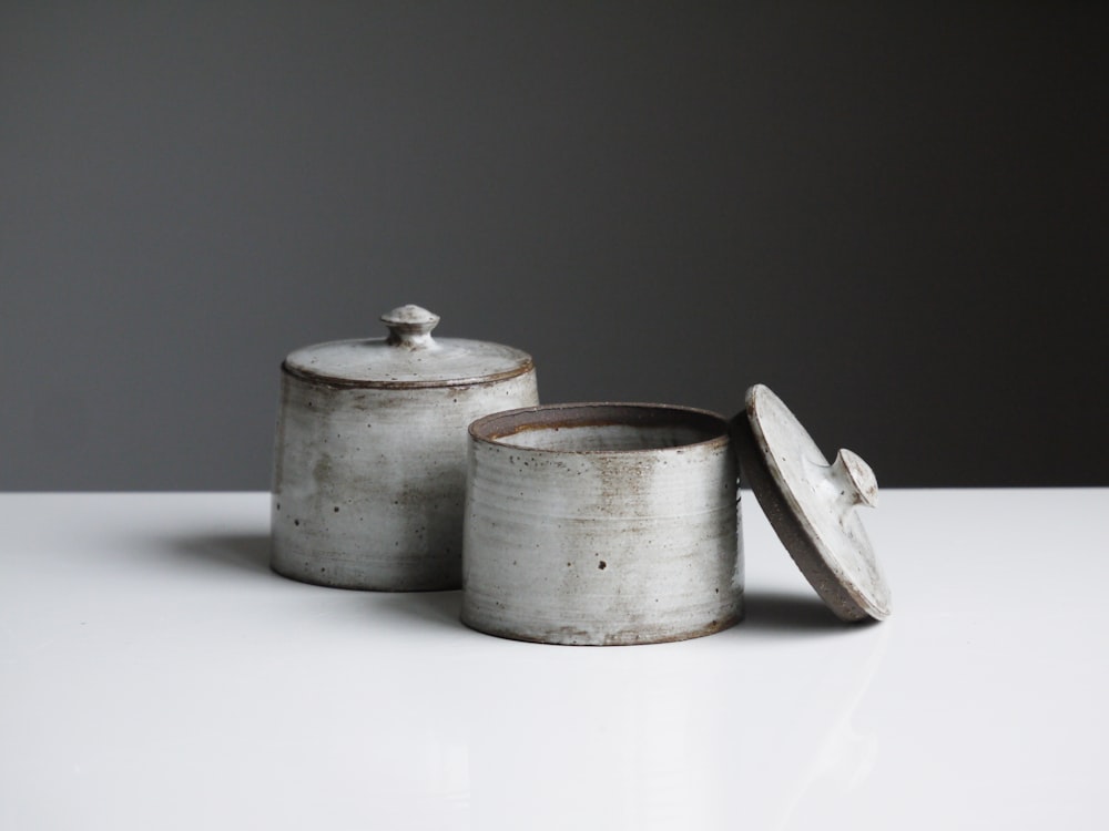 two grey containers on wooden table