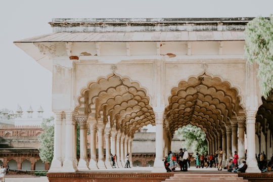 white concrete museum with people in hallway in Agra Fort India