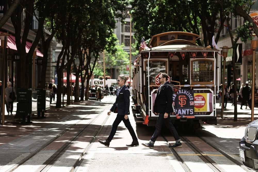 person passing through road beside tram