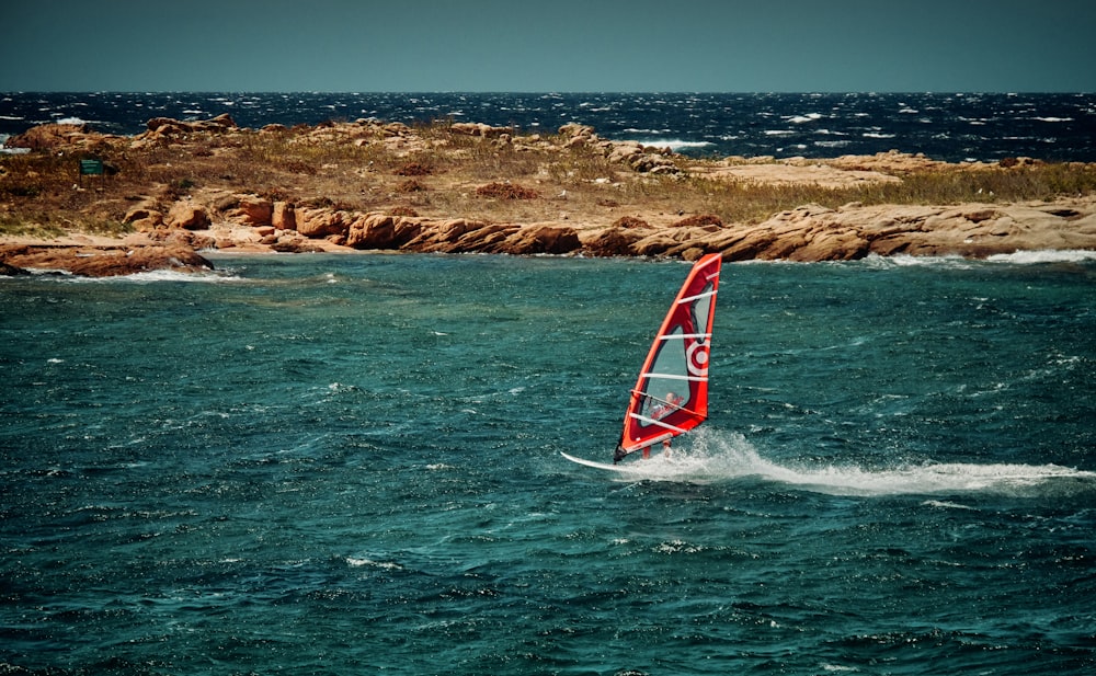 red sailing boat under blue sky