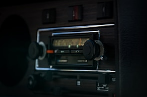 Close-up of an Icom radio device mounted on a vehicle dashboard.