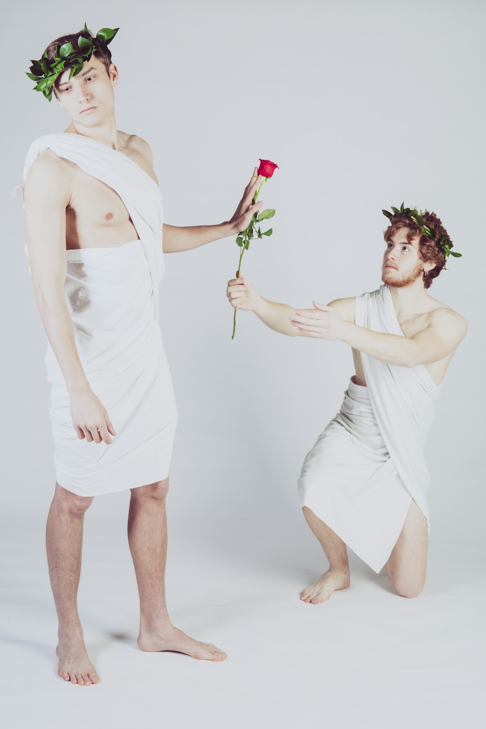 man giving rose to another man