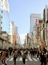 people walking on street in between buildings under blue sky