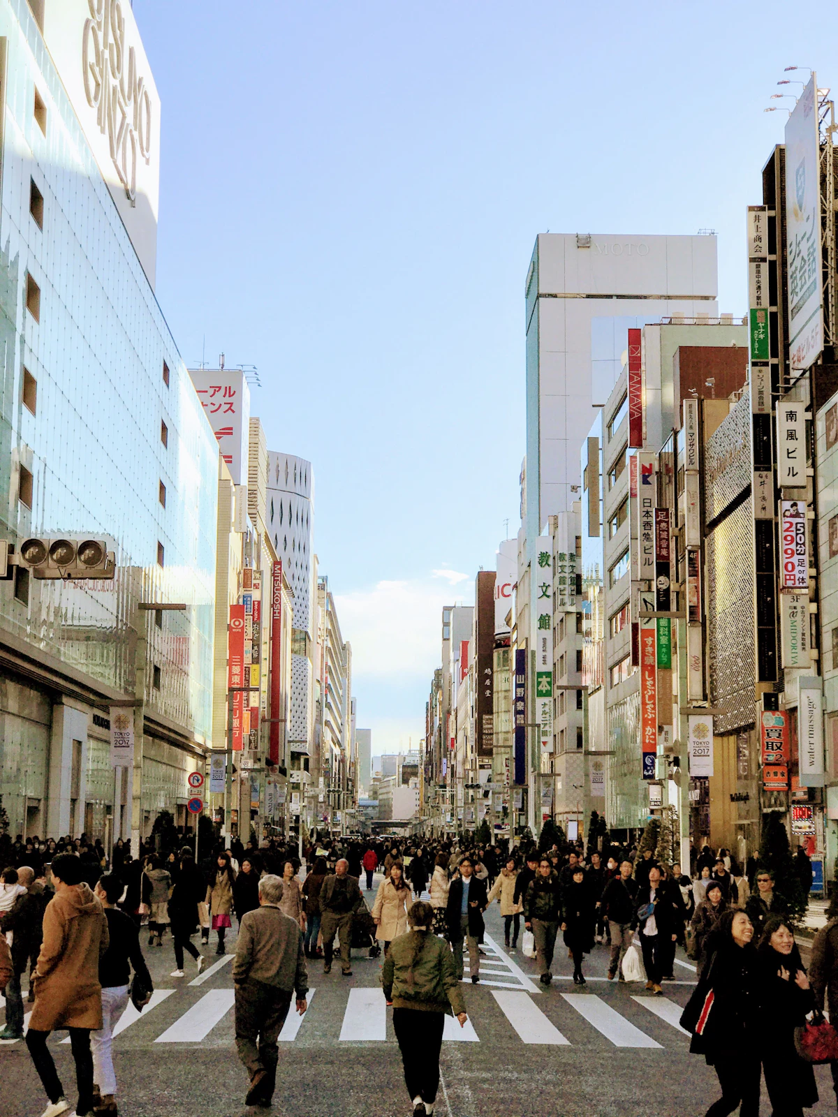 People walking along a Tokyo street lined with shops