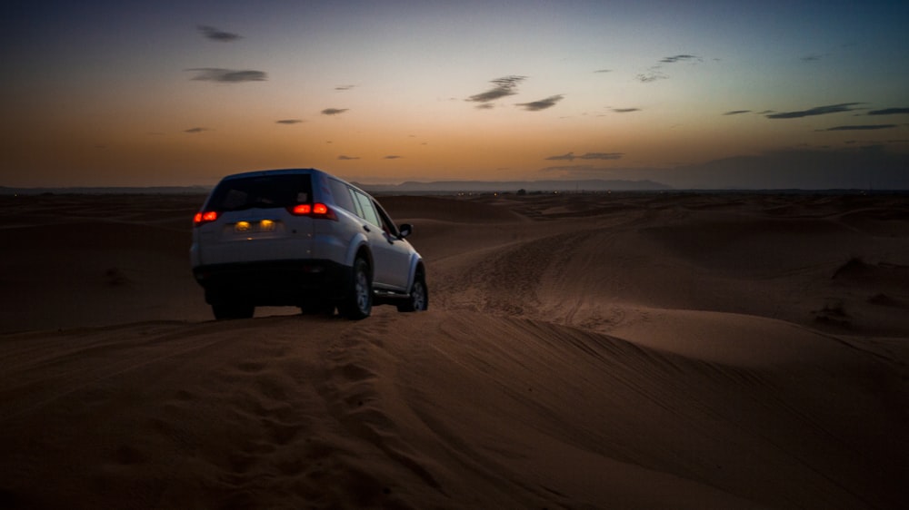 white SUV on desert during daytime