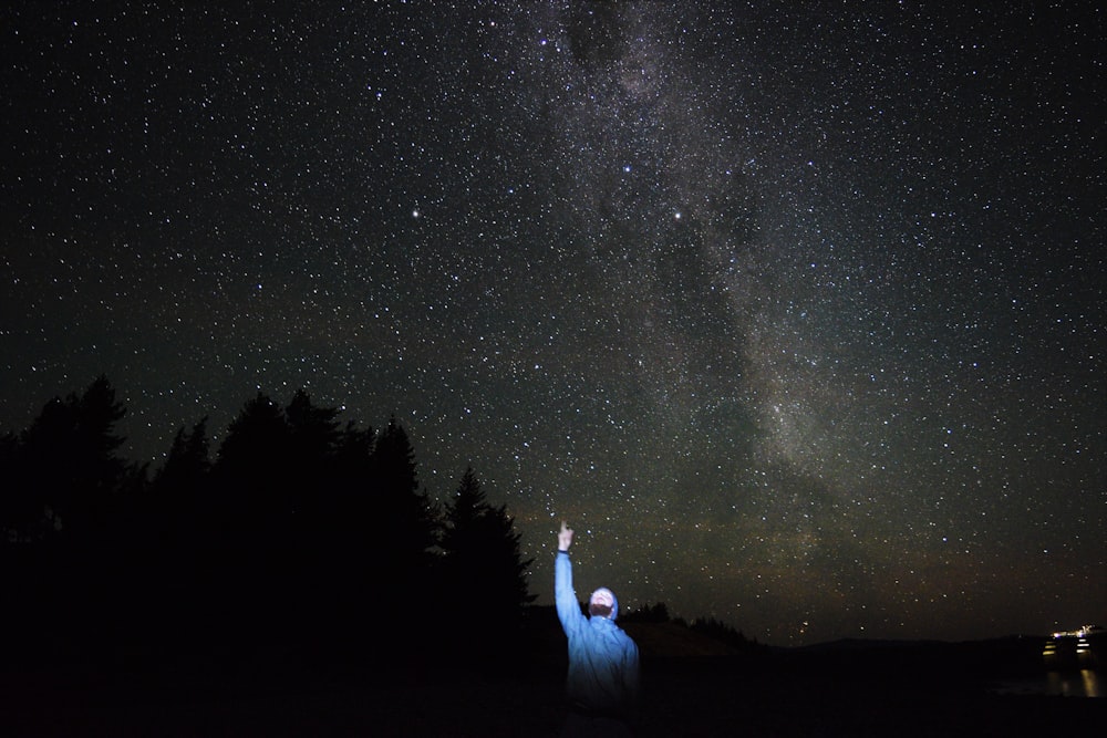 El hombre apunta a las estrellas