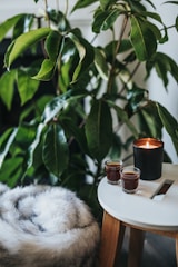lighted votive candle near two shot glasses