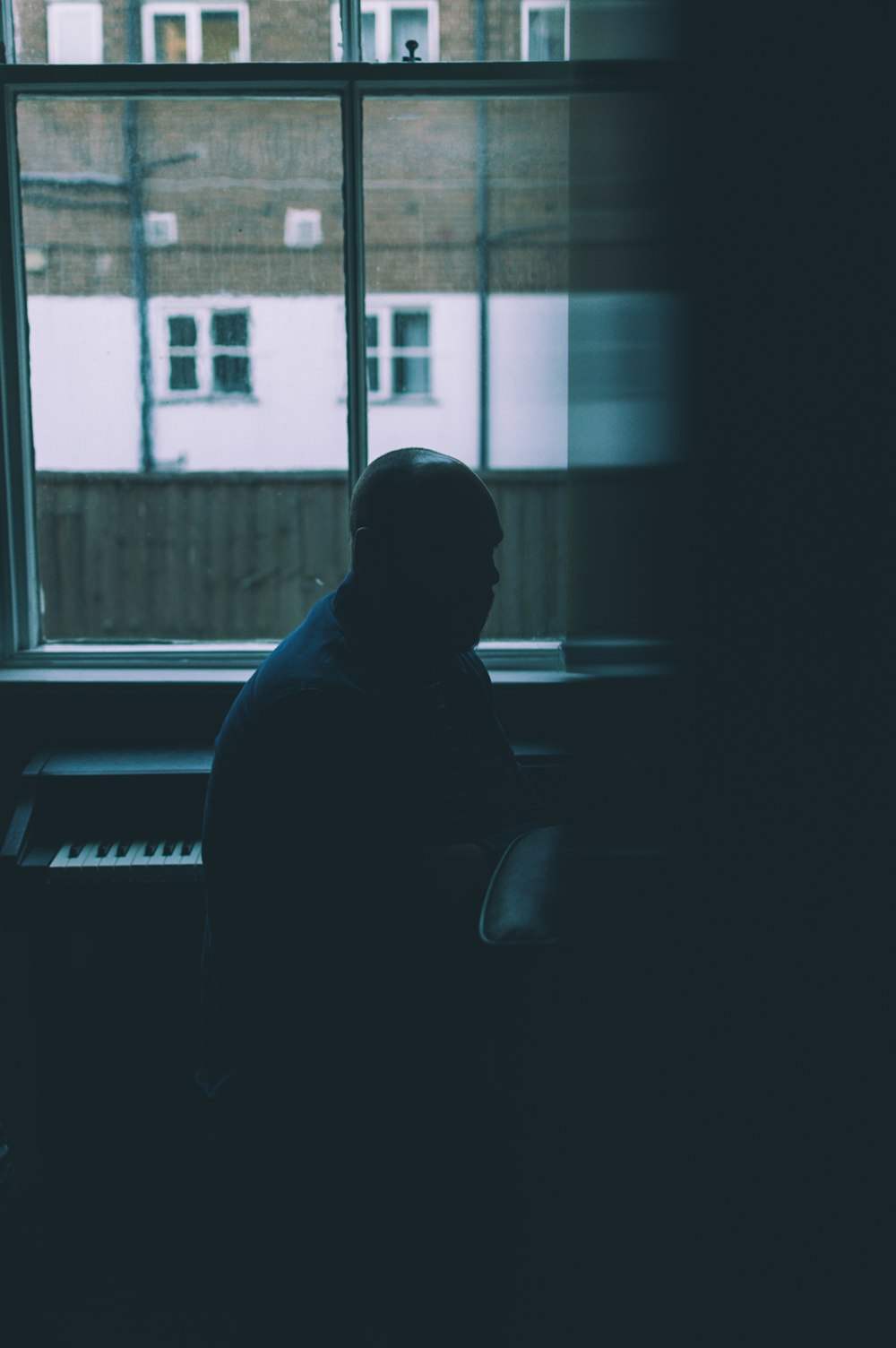 man sitting near piano inside room
