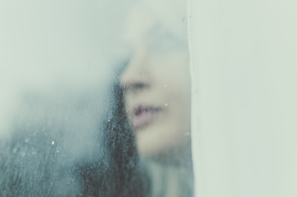 Cara de mujer contra la ventana de cristal