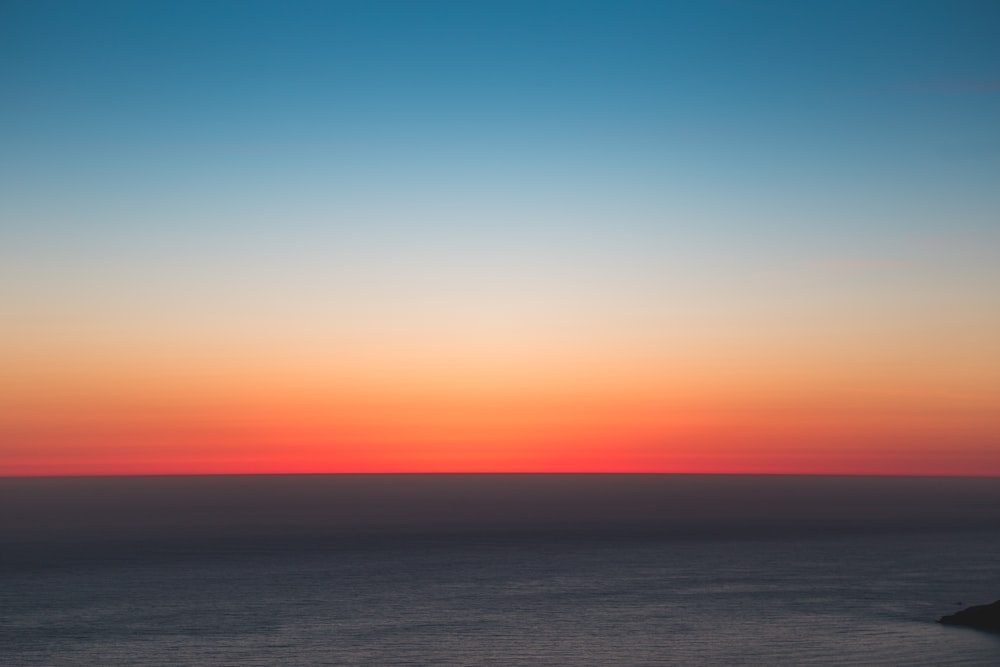 fotografia di paesaggio dello specchio d'acqua sotto il cielo blu