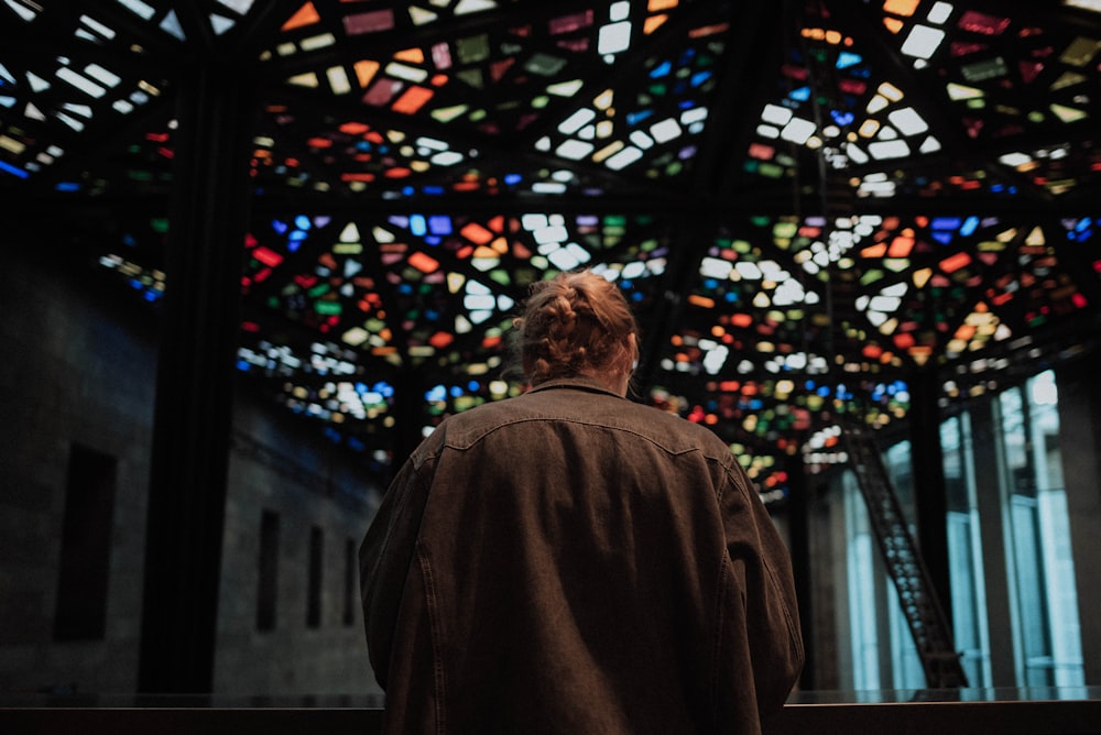 photography of person standing near window