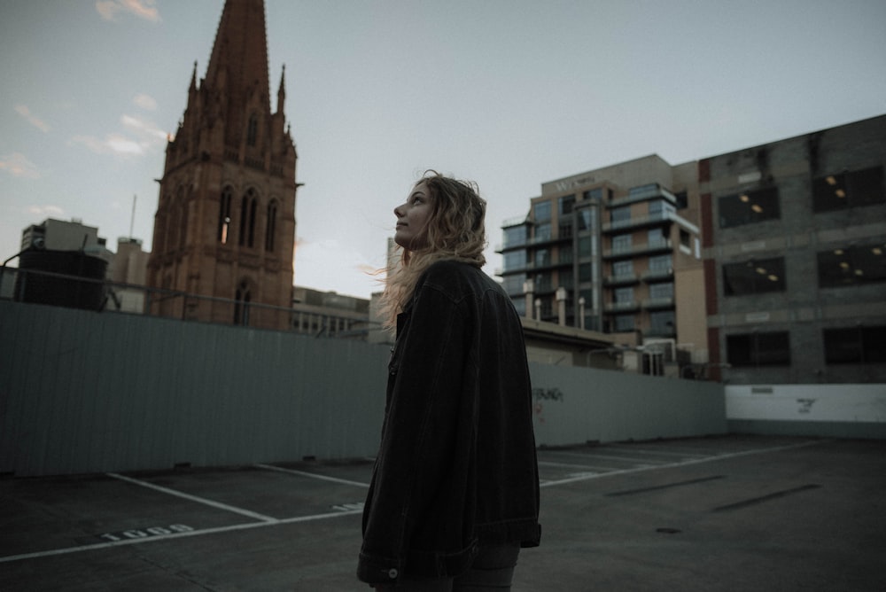 woman standing near cathedral looking at sky