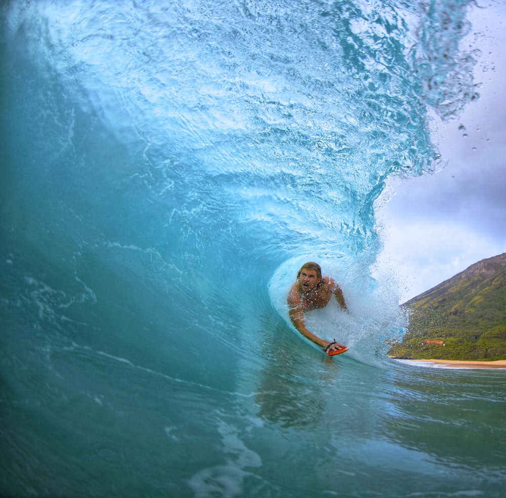 man surfing on seawaves during daytime