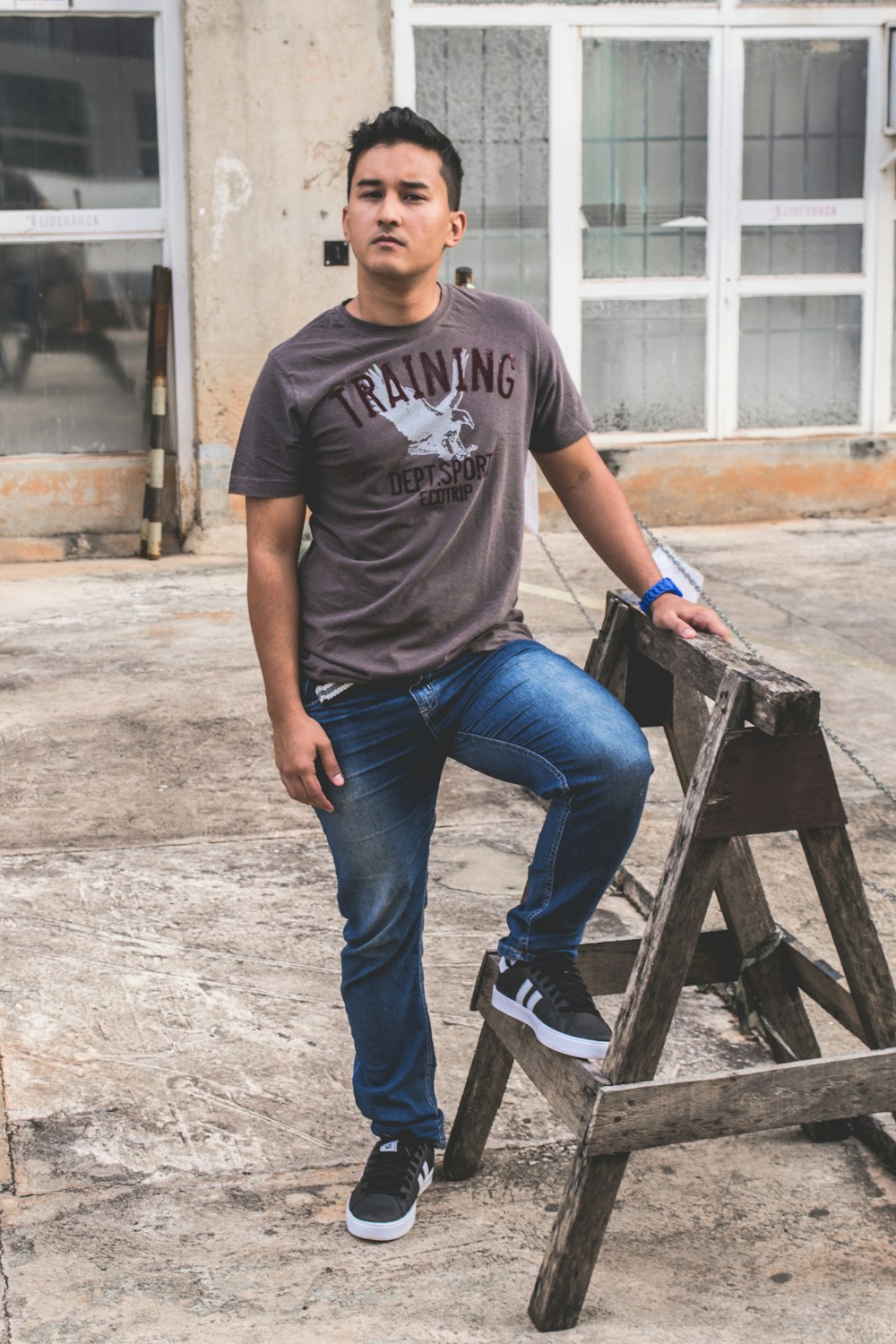 a man sitting on top of a wooden ladder