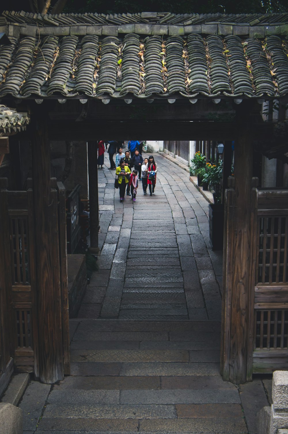 people walking near brown wooden building