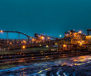 lighted brown concrete buildings near body of water at nighttime