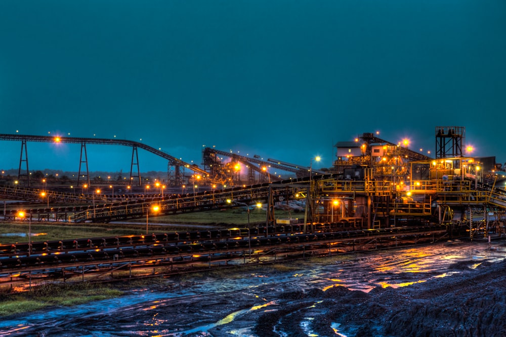 lighted brown concrete buildings near body of water at nighttime