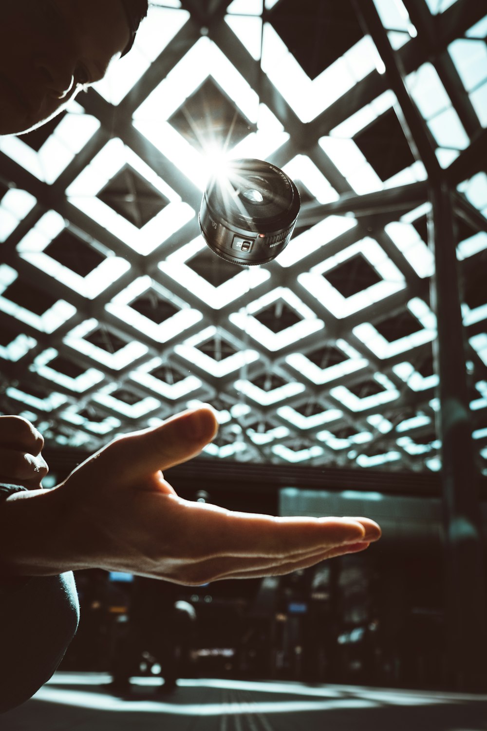 black lens falling towards person's hand