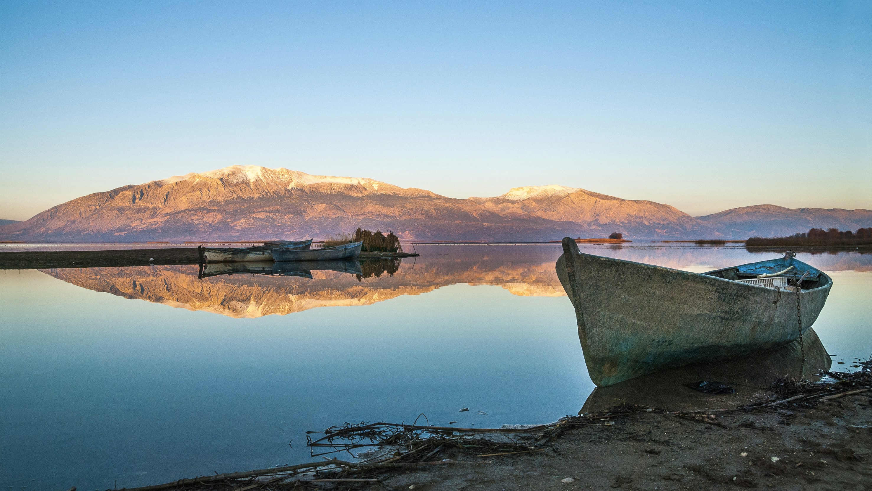 docked gray wooden boat across the brown island