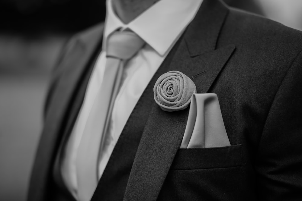 greyscale photo of man wearing peak lapel suit jacket