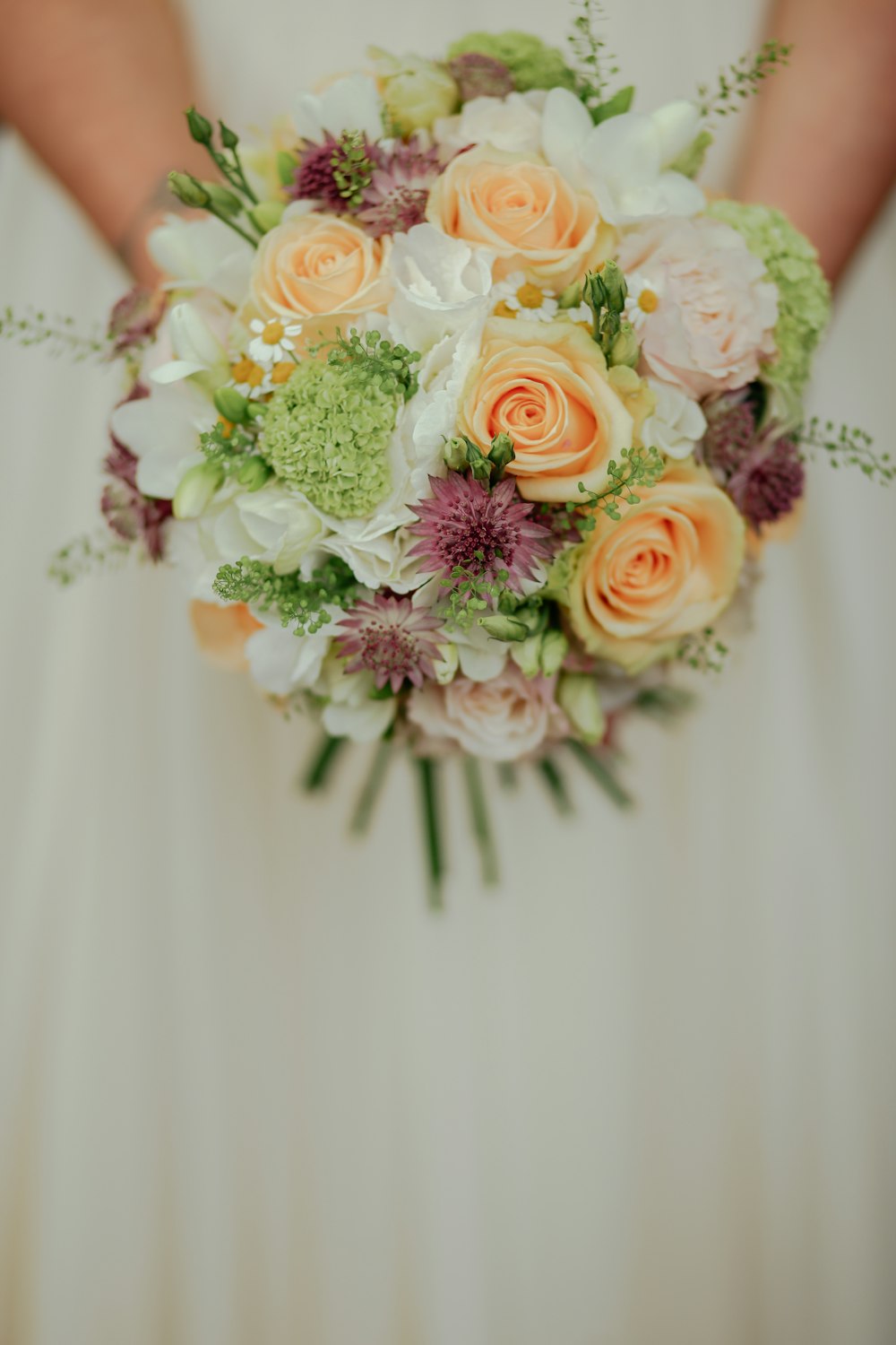 person holding yellow and pink flower bouquet