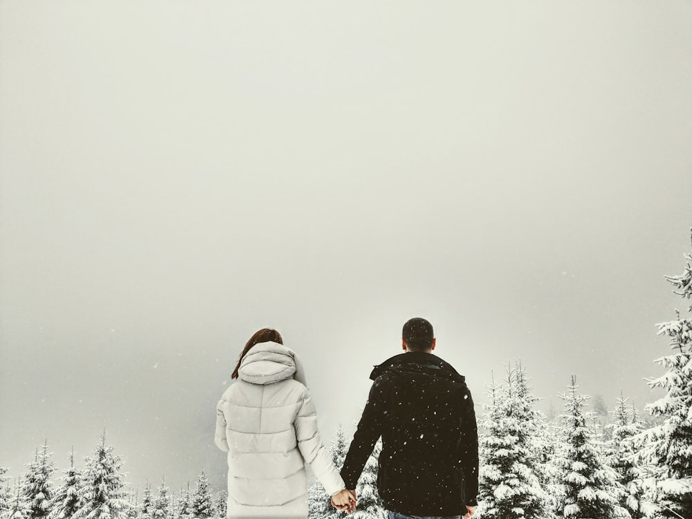 couple holding hands in front of trees