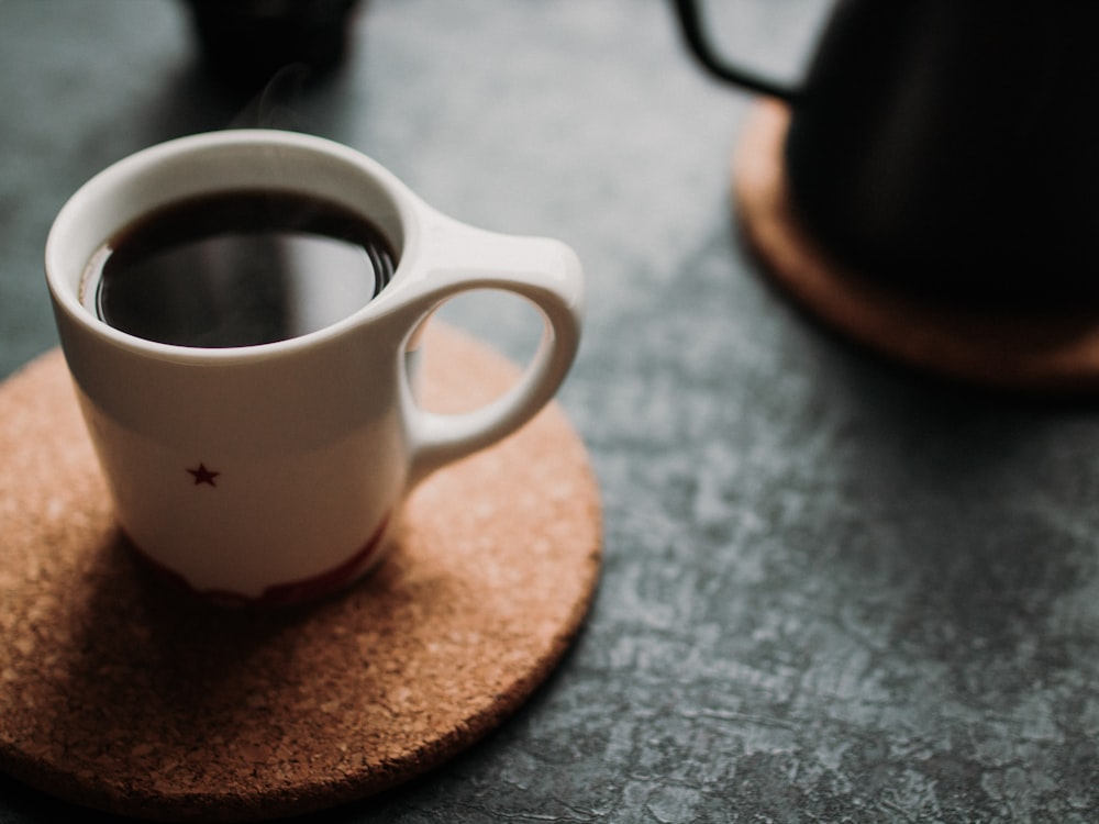 Fotografia de foco seletivo de caneca branca cheia de café