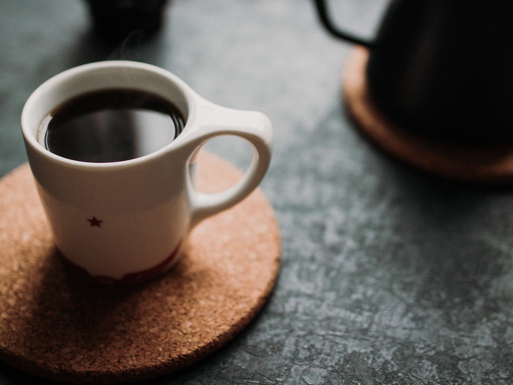 Photographie de mise au point sélective d’une tasse blanche remplie de café