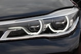 A close-up view of a modern car headlight featuring a sleek design with LED light strips and reflective surfaces.