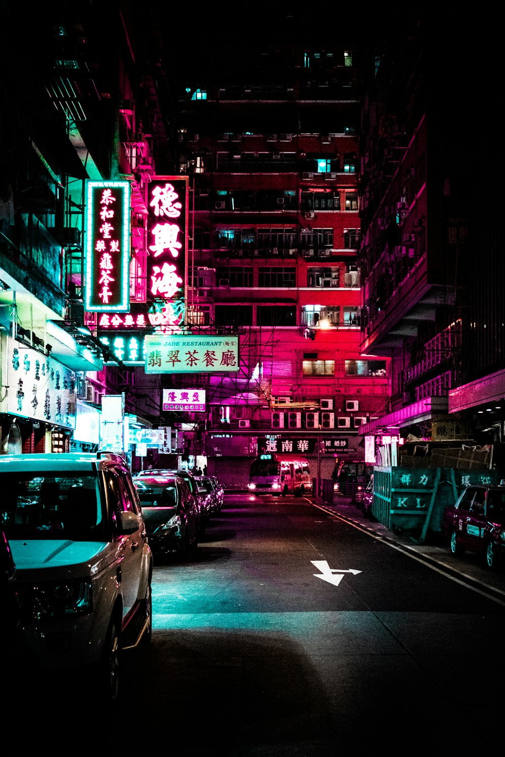 夜間、照明付きの建物の間の車道に駐車する車両