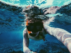 underwater photo of person wearing diving goggles and snorkel