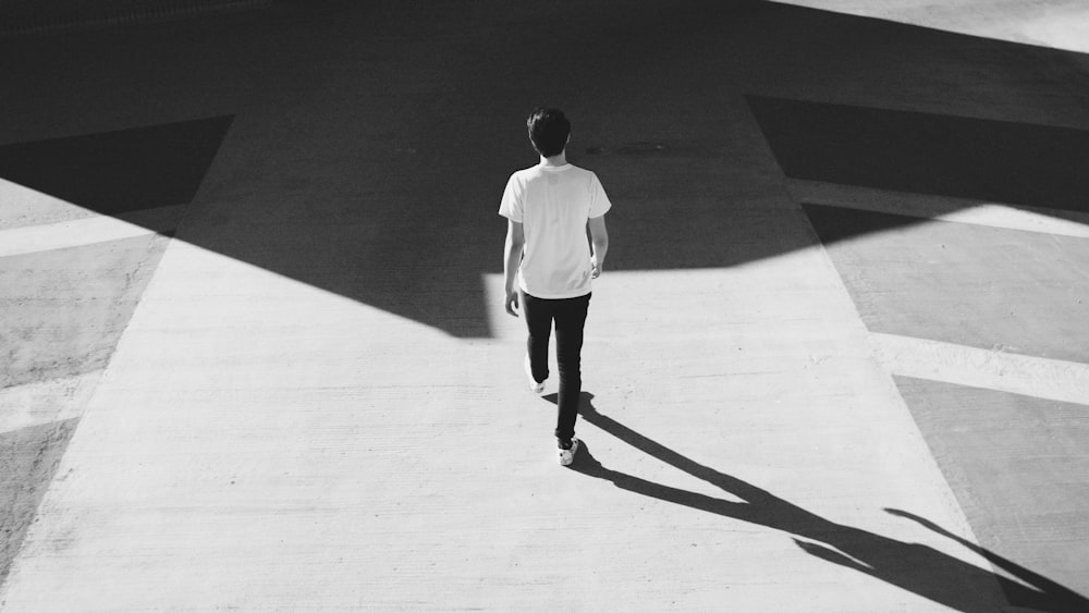 man walking on gray concrete road