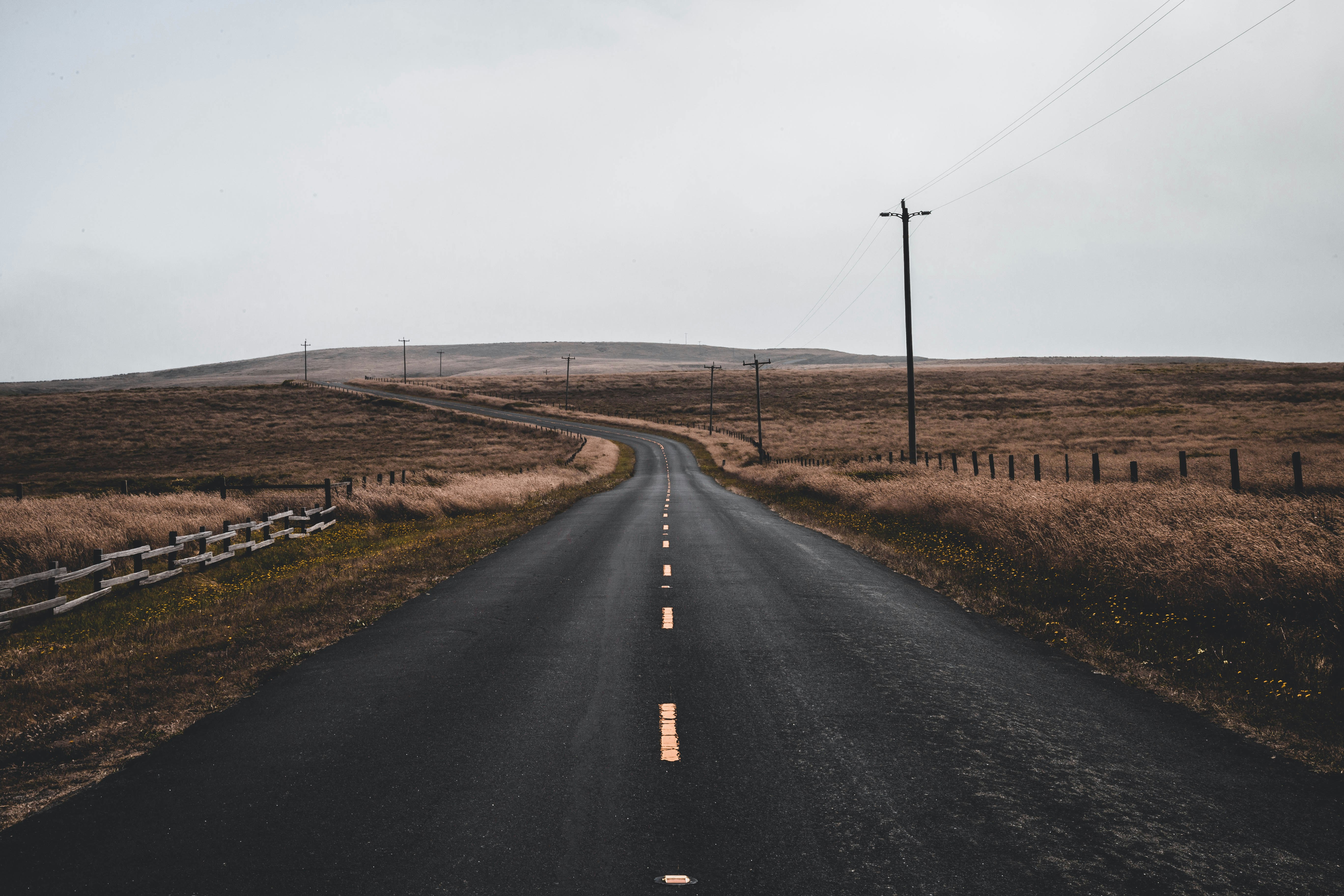 empty black road near utility post