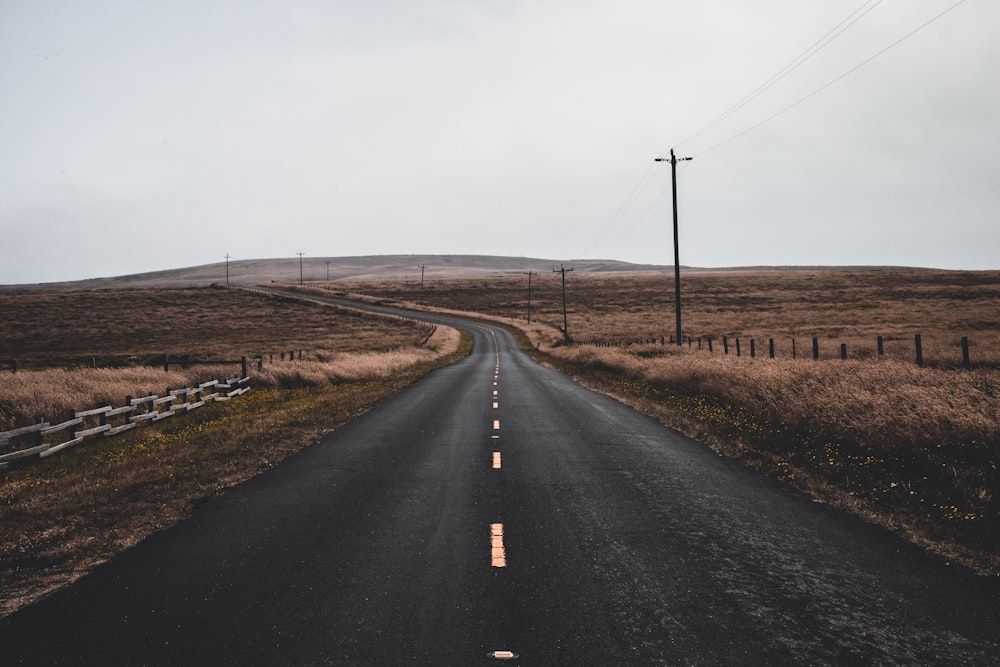 Route noire vide près du poteau électrique