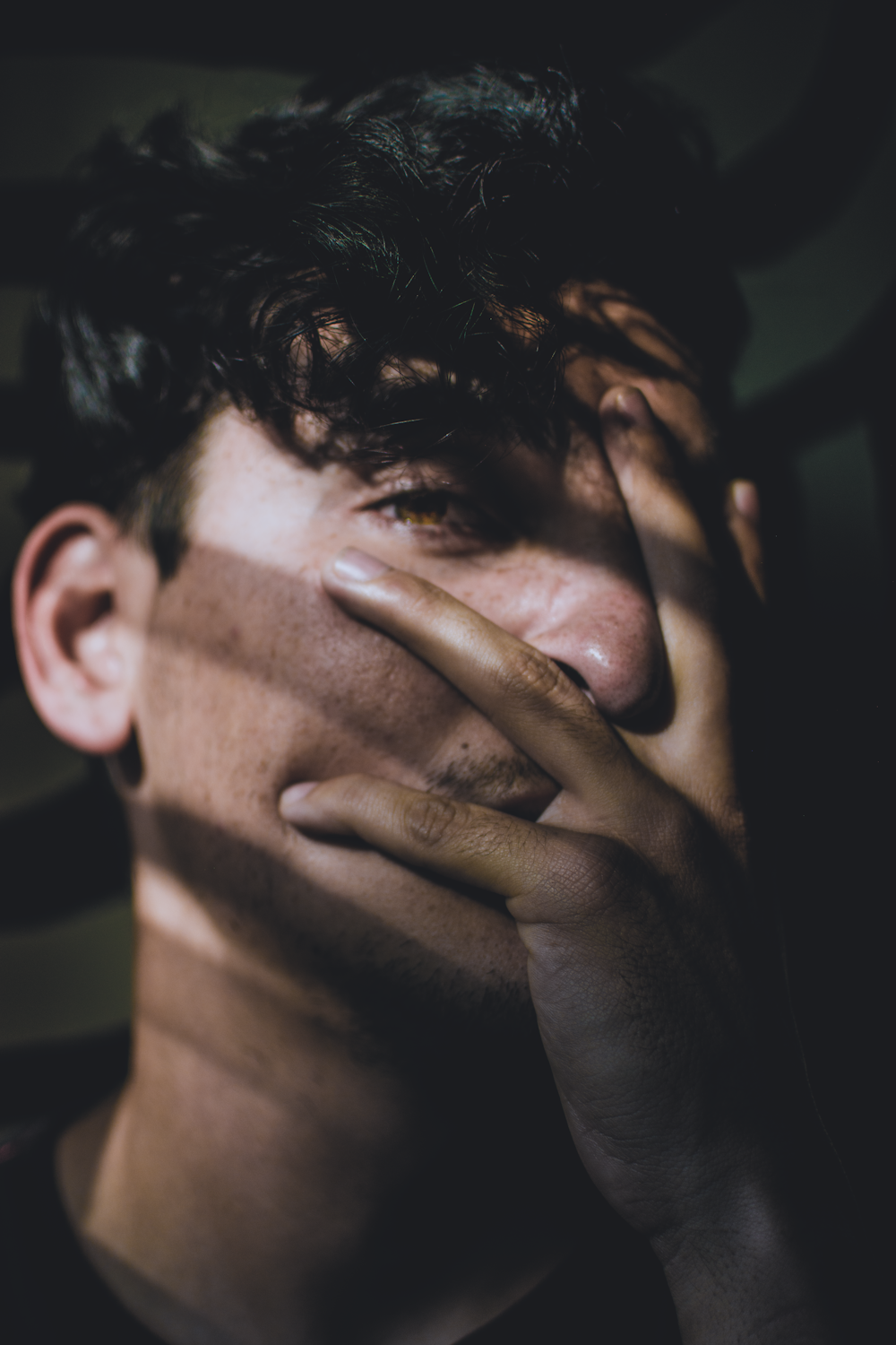 man covering his face using his hand