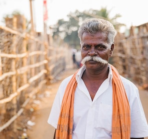 man standing next to brown wall