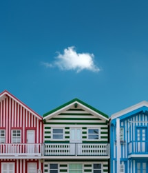 three assorted-color houses next to each other