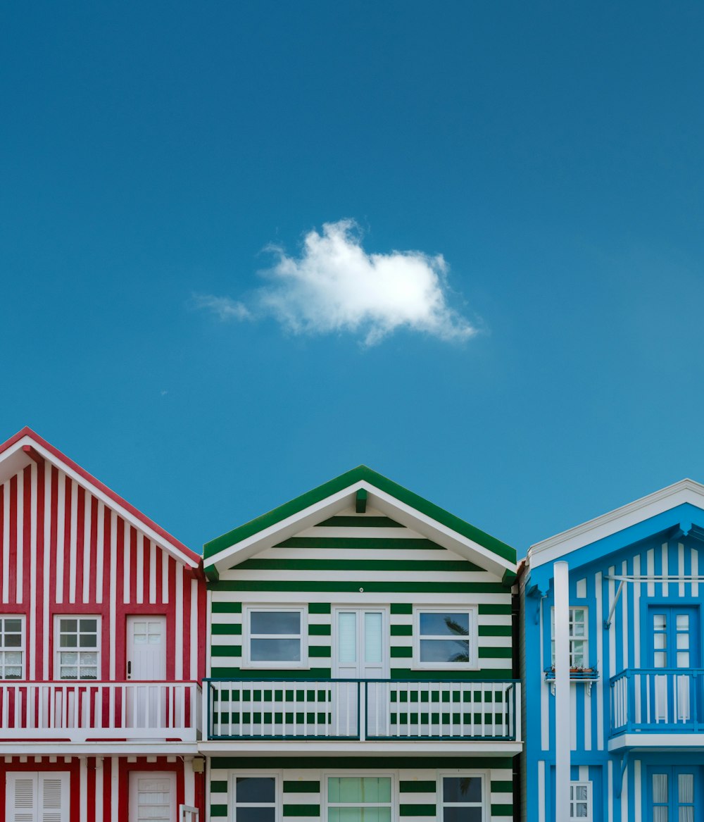 three assorted-color houses next to each other