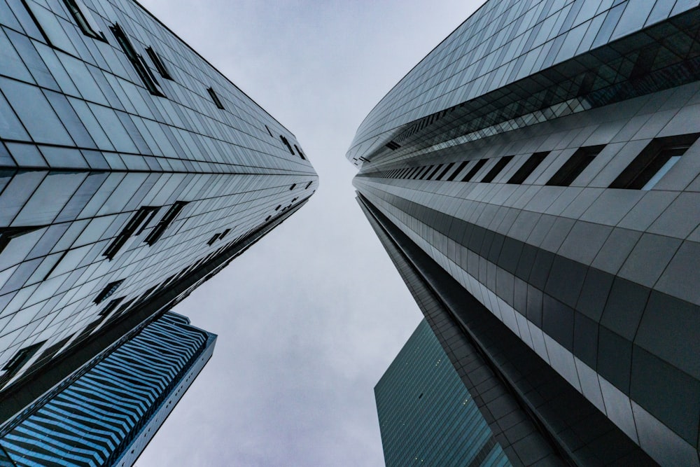 worm's-eye view photography of buildings under cloudy sky