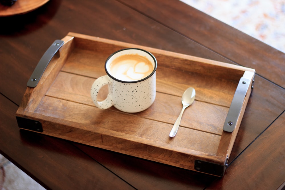 Taza de cerámica blanca en bandeja de madera marrón