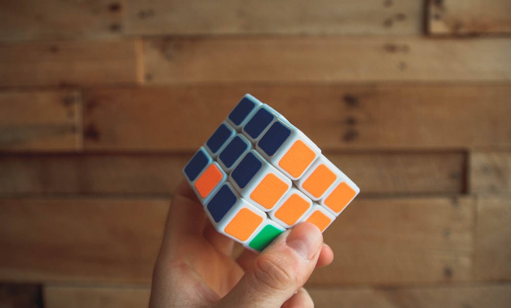 personne tenant un Rubik’s Cube 3x3