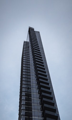 A sleek skyscraper reflecting deep black and metallic gray hues, symbolizing corporate strength and innovation.