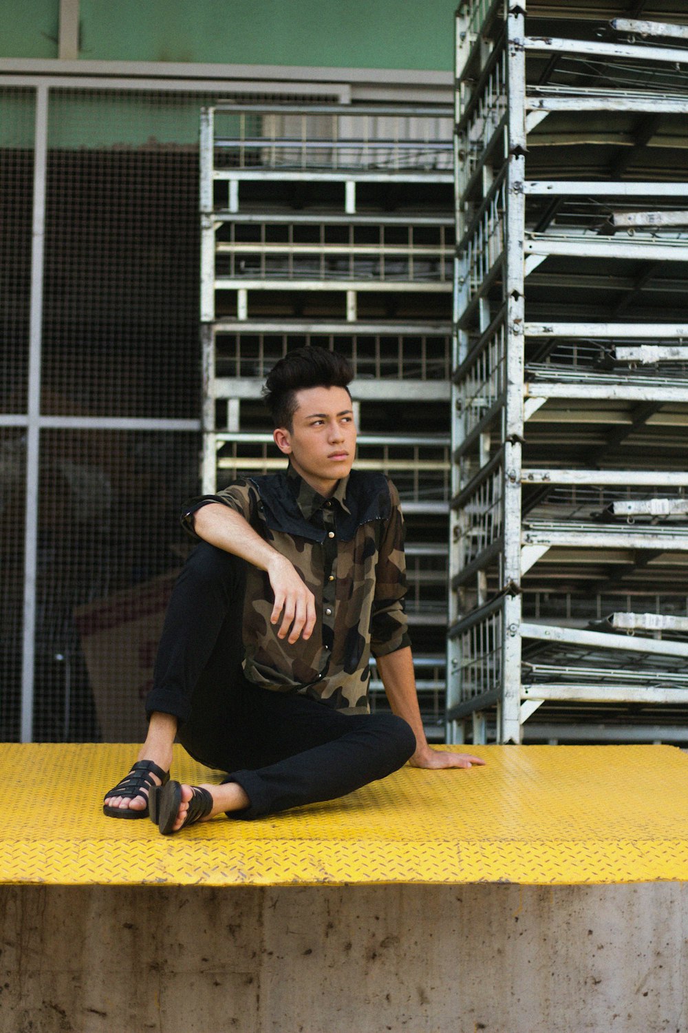 man sitting on yellow surface looking up