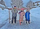 Children playing hockey on the outdoor arena during winter.