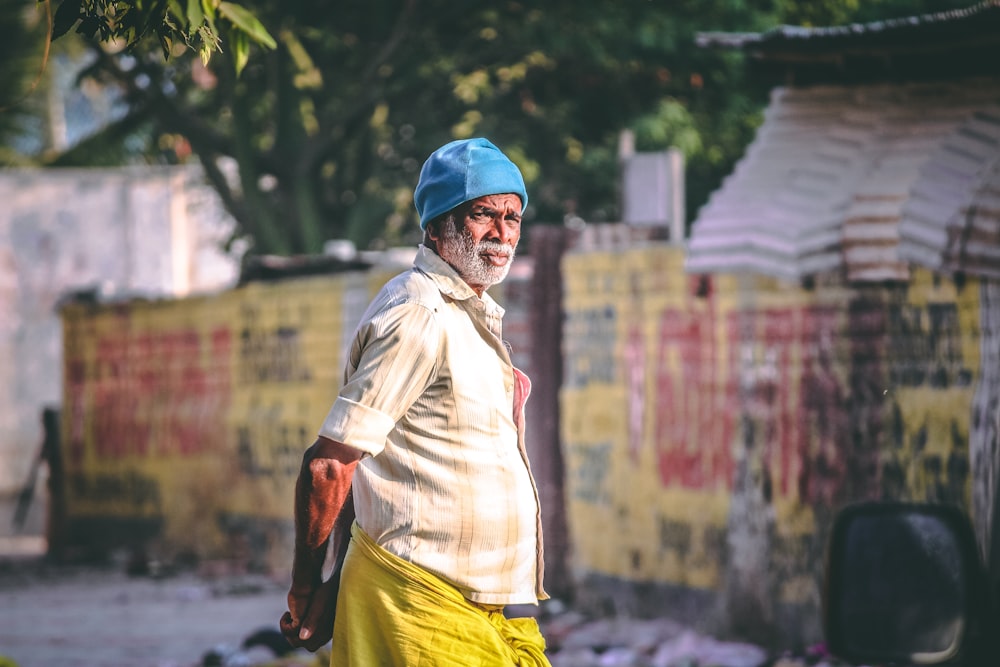 selective focus photography of man wearing blue knit cap standing on streets