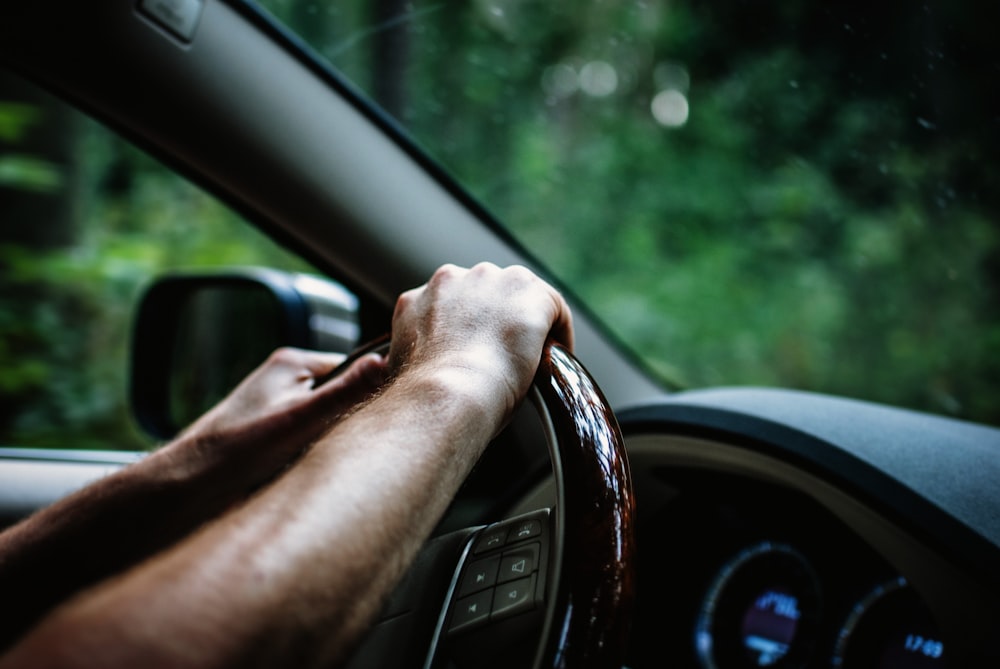 Persona sosteniendo el volante del coche