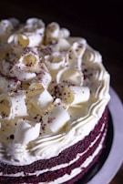 Decadent red velvet cake with cream cheese frosting and sprinkles.